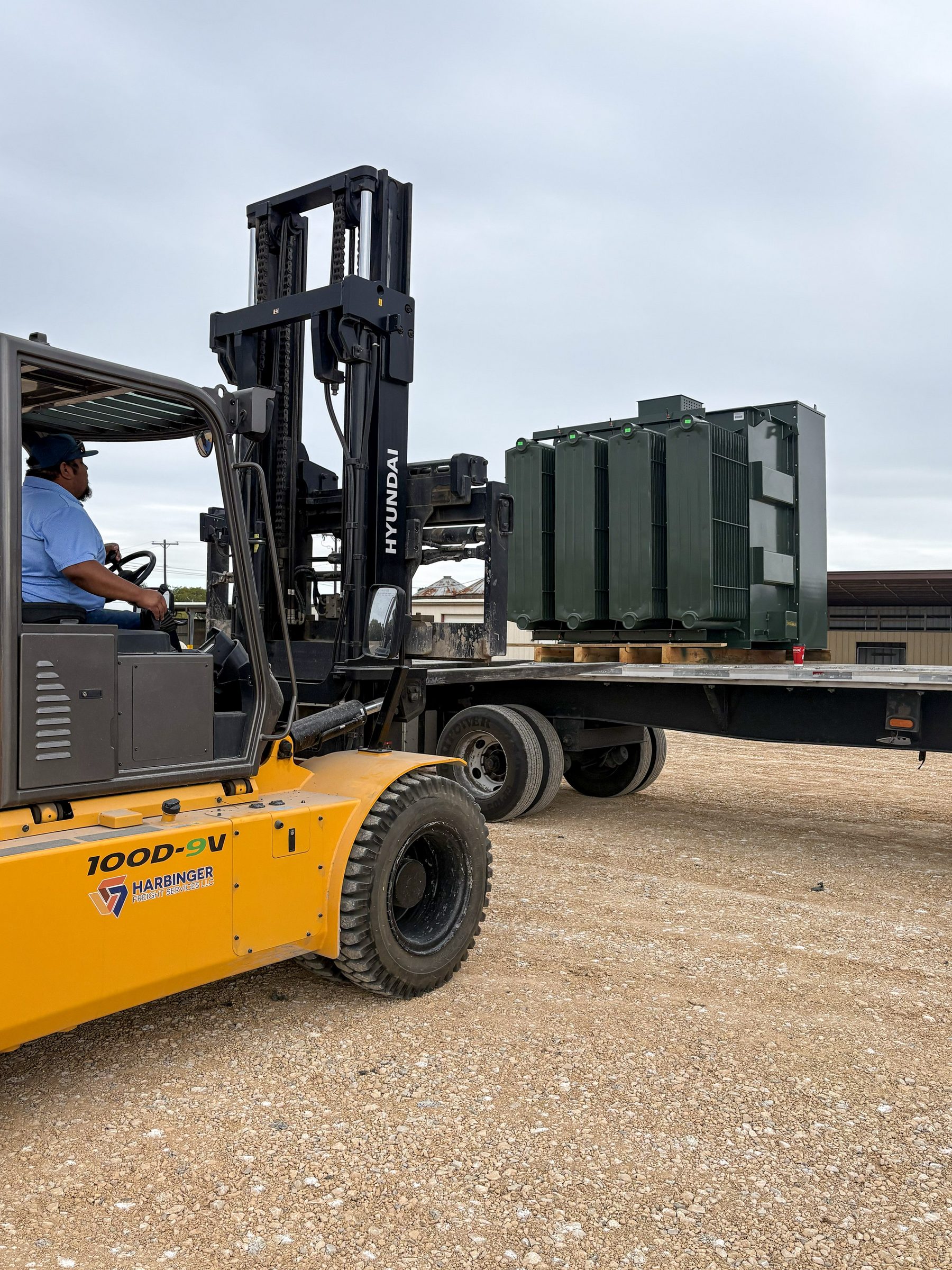 Padmount transformers being unloaded from a flatbed by forklift at the Alvin, Texas yard