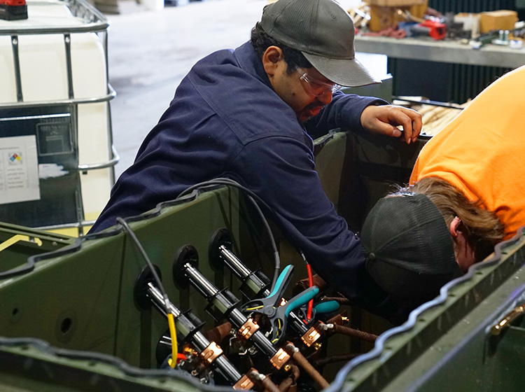 Two JCL technicians working inside an open transformer tank