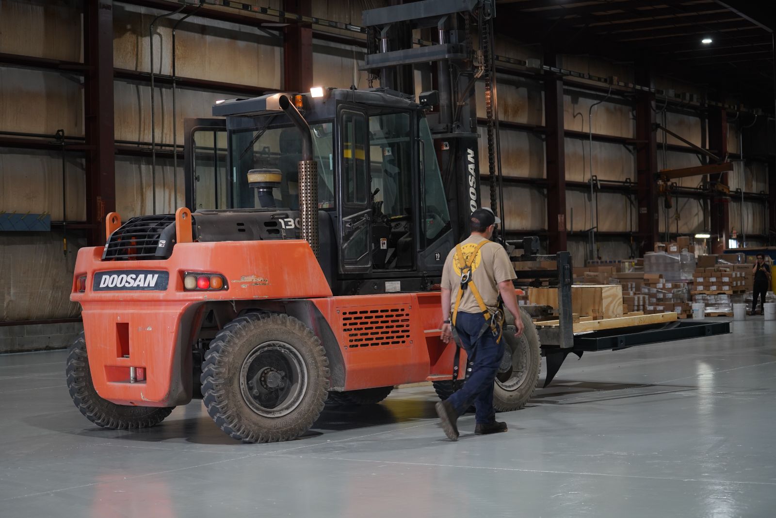 A forklift moving crated equipment inside the JCL warehouse