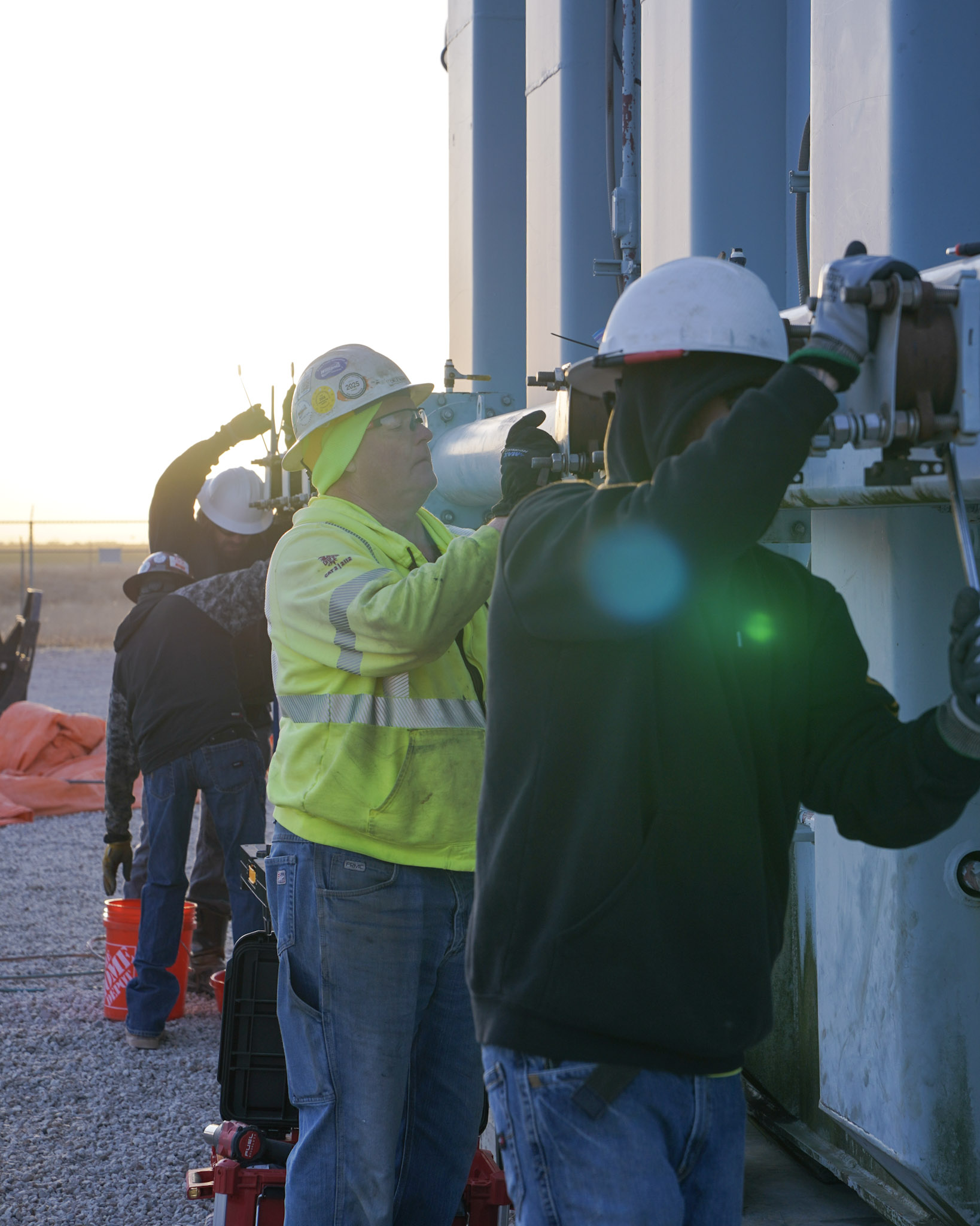 A JCL field crew working on a transformer at sunrise