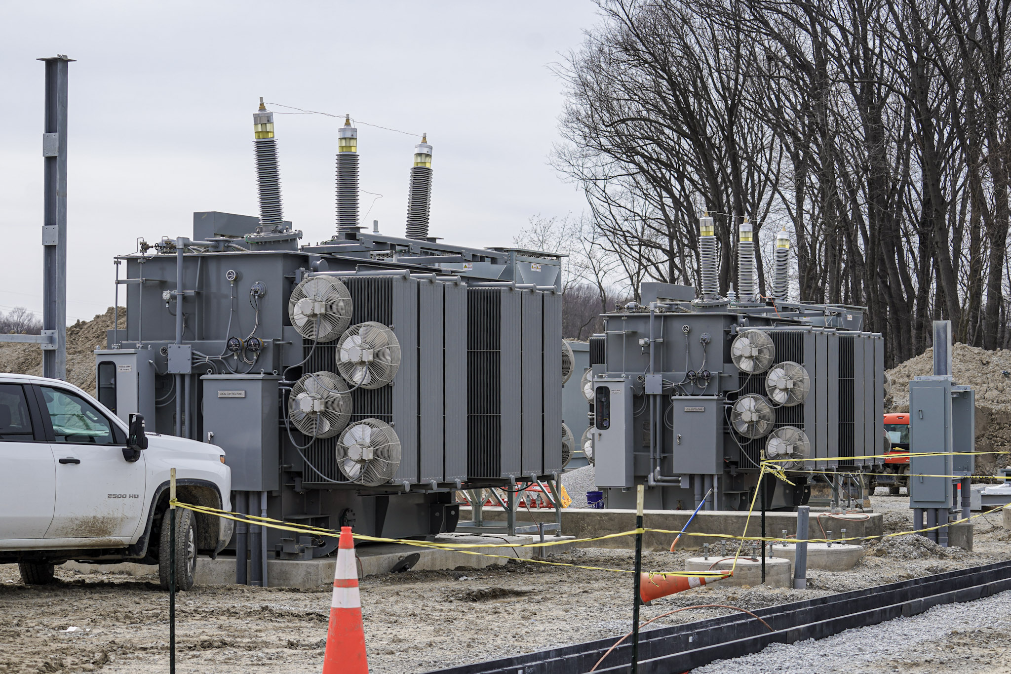 Two substation transformers staged on a utility construction site