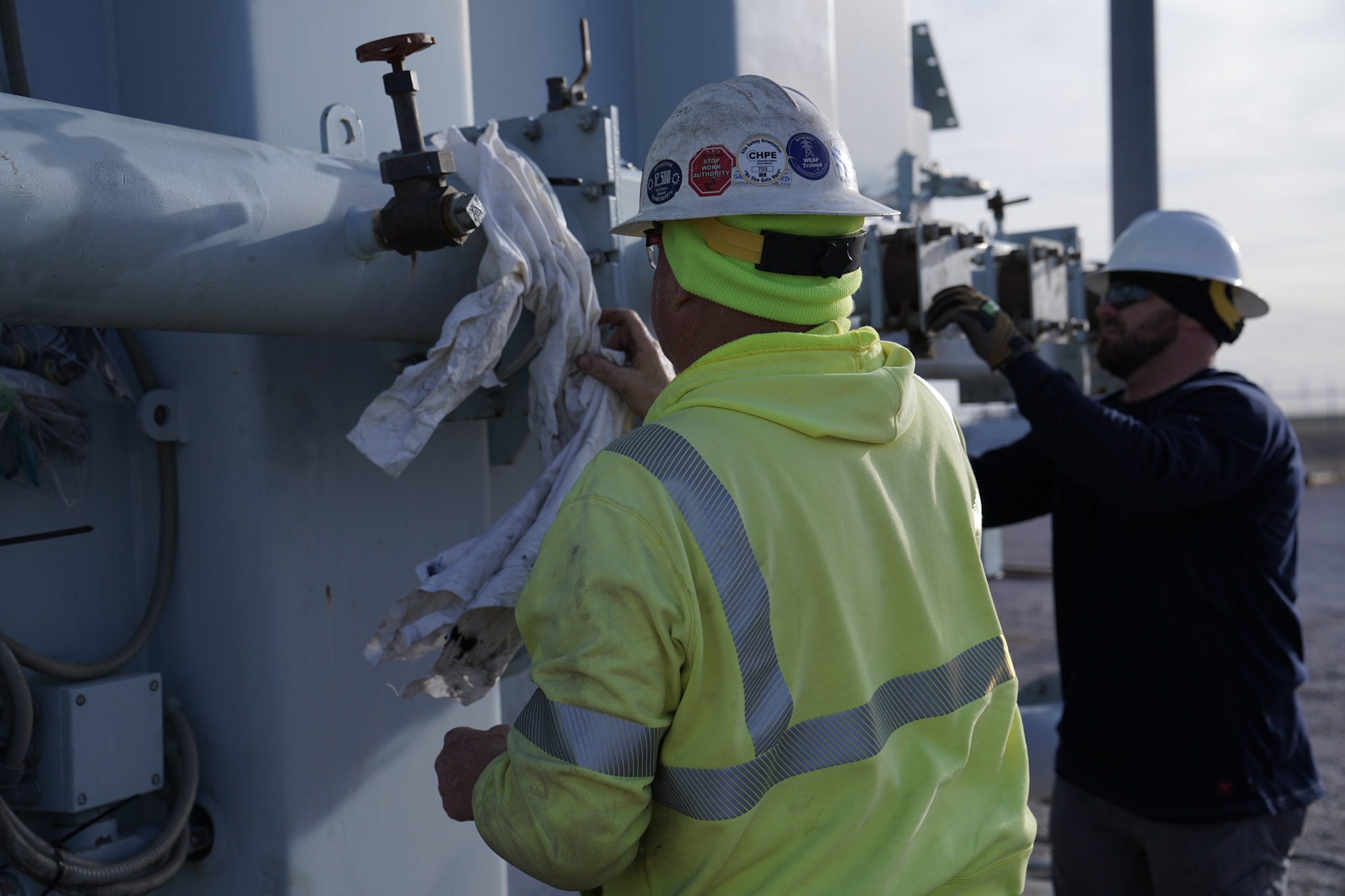 A JCL technician wiping down a padmount transformer during a scheduled service visit